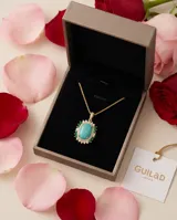 Collar de cadena fina con baño de oro y dije ovalado con piedra central color turquesa, rodeada por un marco de circonias blancas y pequeñas piedras verdes.