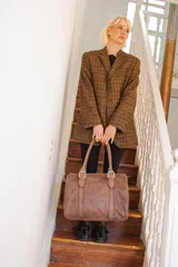 Bolso de mano tipo shopper marca Amadea, confeccionado en cuero con acabado desgastado. Presenta detalles de costuras decorativas verticales, correas con hebillas metálicas doradas y logo grabado al frente.