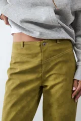 Pantalón de tiro medio color verde oliva, confeccionado en tejido con efecto gamuza. Presenta cierre frontal con cremallera, presillas para cinturón y corte recto.