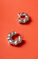 Aro tipo argolla de metal plateado con diseño trenzado.