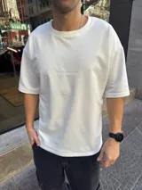 Remera color blanco hueso de algodón pesado, corte holgado y cuello redondo.