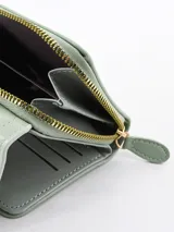 Billetera compacta de color verde menta, con solapa frontal que presenta una textura tipo cocodrilo y un cierre central con botón metálico dorado.