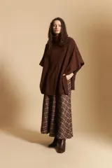 Poncho de tejido de punto color gris, con cuello alto y mangas amplias de diseño holgado.