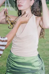 Top color beige claro, con escote drapeado tipo cascada y tirantes finos.