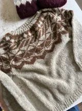 Sweater de punto tejido a mano en mohair, con diseño de canesú estampado en tonos azul, rojo, blanco y turquesa. Presenta cuello redondo y mangas largas.