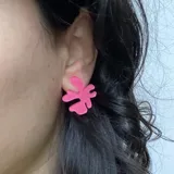 Par de aros con forma abstracta de flor color fucsia.