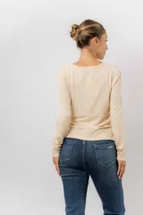 Remera de manga larga color beige, con escote redondo levemente abierto y calce regular. Confeccionada en tejido suave, liviano y con leve elasticidad.