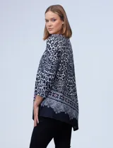 Buzo de tejido soft estampado animal print en tonos blanco, negro y gris, con ruedo asimétrico y mangas tres cuartos.