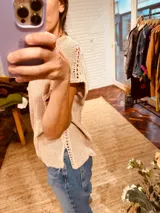 Remera tejida en lurex color rosa con detalles dorados y contornos en crochet, de mangas cortas y cuello en V.