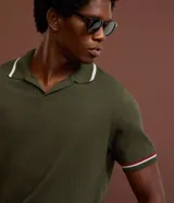 Camisa polo Marfinno de tejido de punto en color verde militar, con cuello en V y mangas cortas. Presenta detalles contrastantes en blanco y bordó en el cuello y en los puños.