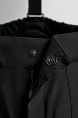 Pantalón deportivo de esquí color negro, confeccionado en tejido técnico impermeable de tres capas con costuras y cremalleras termoselladas. Cuenta con tirantes elásticos regulables, cintura ajustable, bolsillos frontales con cierre, refuerzos en la parte inferior de la pernera y sistema de rescate RECCO integrado.