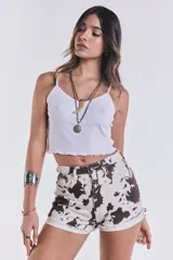 Short de jean con estampado de vaca, corte mom y ruedo desflecado.