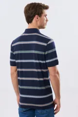 Remera polo de manga corta con diseño a rayas horizontales en tonos azules, celestes, verdes y beiges sobre base azul marino. Presenta cuello camisero con cierre frontal de botones y un pequeño logo bordado en el pecho.