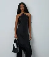 Vestido negro de satén con escote halter y tirantes finos ajustables. Presenta un bajo asimétrico con acabado de encaje.