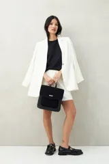 Mochila estructurada color marrón oscuro, con frente en acabado gamuzado y cuerpo en símil cuero texturizado. Tiene asa superior y correas regulables.