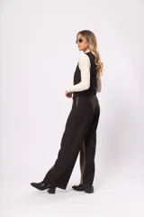 Pantalón de tiro alto con bolsillos delanteros y traseros, cierre frontal con cremallera y botón. Diseño a bloques en negro y verde.