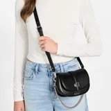 Cartera tipo bandolera Guess modelo Carrie, color negro, con diseño de solapa redondeada y cierre frontal. Presenta herrajes metálicos dorados, incluyendo el logo de la marca en el centro y una correa combinada de cuero sintético y cadena.
