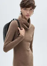 Vestido midi de punto color marrón, con cuello alto vuelto y mangas largas. Presenta un diseño ajustado al cuerpo con caída fluida.