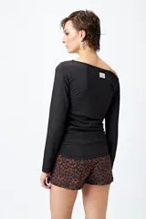 Top blanco elastizado al cuerpo, con cuello recto asimétrico y frunces laterales.