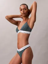 Bombacha tipo colaless Calvin Klein de tiro alto, confeccionada en una mezcla de algodón y modal. Presenta un estampado geométrico con el logo de la marca y una banda elástica blanca en la cintura con el nombre de la marca repetido.