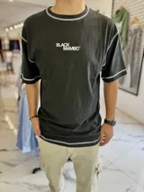 Remera oversize negra con costuras a la vista en color blanco y estampa frontal de texto Black Mambo.