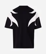 Remera boxy de algodón y poliéster color negro, con cuello redondo, manga corta y aplicaciones gráficas de llamas blancas en los laterales y las mangas.