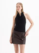 Top negro sin mangas con cuello halter drapeado.