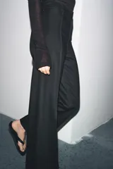 Jeans de tiro alto, pierna ancha y largo al tobillo, en denim celeste claro con efecto lavado. Presenta costura marcada en el centro de cada pierna y cierre frontal con cremallera y botón.