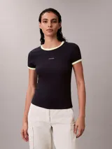 Remera Calvin Klein de corte baby fit y manga corta, confeccionada en tejido acanalado negro. Presenta cuello redondo y puños con ribetes en contraste blanco y amarillo fluo, y el logo de la marca bordado en el pecho.