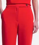 Pantalón flare de sastrería color rojo, con cintura alta, trabillas y cierre cruzado con botones.