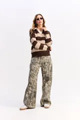 Buzo de tejido liviano con diseño de rayas horizontales en azul marino y gris, cuello tipo polo en color crema y mangas largas.