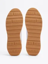 Zapatillas Tommy Hilfiger Classics de hombre, color blanco con detalles en gris y suela color caramelo. Confeccionadas en piel con interior de poliéster y suela de EVA dentada.