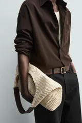 Bolso tipo shopper de tejido de algodón color beige, con diseño de red exterior y compartimento principal con cierre de imán. Cuenta con asa de mano oscura a contraste y bolsillos interiores.