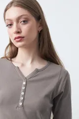 Remera de manga larga color marrón, confeccionada en algodón, con escote en V y cartera corta de botones.