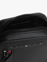 Cartera cruzada para teléfono de Tommy Hilfiger, color negro, con diseño compacto y funcional. Presenta un bolsillo frontal con cierre y detalles distintivos de la marca en los colores icónicos, además del logo metálico en la parte superior.
