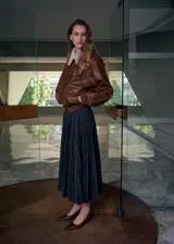 Falda midi plisada de color gris oscuro, con corte acampanado y diseño fluido.