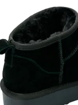 Bota corta de estilo casual, confeccionada en cuero negro con interior forrado en poliéster. Presenta una suela de plataforma de goma negra y un diseño minimalista de caña baja.