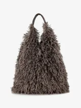Cartera de diseño amplio y estructura flexible, confeccionada en textura de pelo sintético que aporta volumen. Cuenta con asas cortas integradas para llevar al hombro o en la mano.