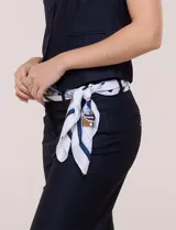 Pashmina de satén estampado en tonos blanco, azul marino y dorado, con diseño clásico de cadenas y detalles ecuestres.