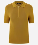 Blusa polo de punto color mostaza, ajustada al cuerpo, con cuello y manga corta. Presenta una cremallera frontal que llega hasta el escote.