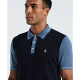 Polo de punto con diseño color block, combinando un cuerpo central en azul marino con mangas y cuello en azul claro. Presenta cierre frontal de tres botones y logo bordado en el pecho.