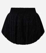 Minifalda negra de jacquard con tiro alto, cintura estructurada y corte baloné voluminoso.