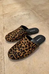 Slippers con estampado animal print, forro interior y plantilla de cuero color negro.