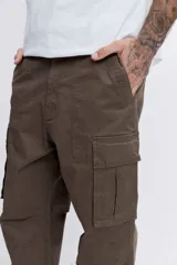 Pantalon cargo de corte holgado en color marrón, con bolsillos laterales con solapa y cierre frontal.