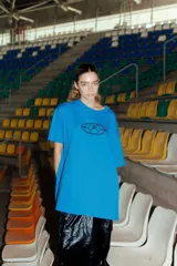 Remerón de corte oversized color azul, con cuello redondo y estampa gráfica circular en el frente.