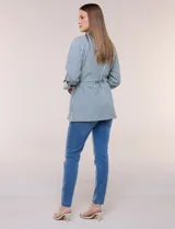 Campera liviana de algodón con estampado de rayas azules y blancas, corte semi holgado con cordón ajustable en la cintura. Cuenta con cuello camisero, cierre frontal con botones, bolsillos con solapa en la parte inferior y mangas largas regulables.