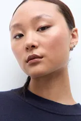 Sweater azul marino de manga larga con cuello redondo, combinado con una camisa celeste que se asoma por debajo.