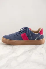 Zapatillas de gamuza azul con detalles en fucsia y suela marrón.