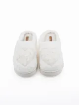 Pantuflas de peluche color blanco con diseño de corazón en relieve en la parte superior y suela de plataforma acolchada.