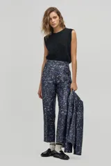 Pantalón sastrero de tiro alto con estampado de leopardo en tonos azulados, corte carrot, cintura ceñida con pliegues frontales, bolsillos laterales y bolsillo de ojal trasero.